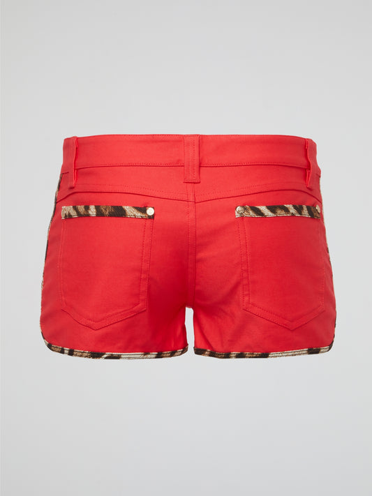 Unleash your wild side with our red leopard trim shorts by Roberto Cavalli, guaranteed to turn heads everywhere you go. The luxurious material and bold print make these shorts the perfect statement piece for any fashion-forward individual. Embrace your inner fashionista and show off your unique and fearless style with these must-have shorts.