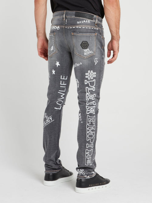 Серые джинсы с рисунками и заплатками